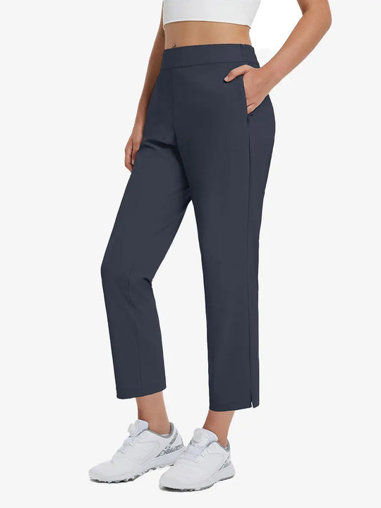 Front lower-body view of model with right hand in pocket wearing NAVY Women's 7/8 Ankle Golf Track Pants.