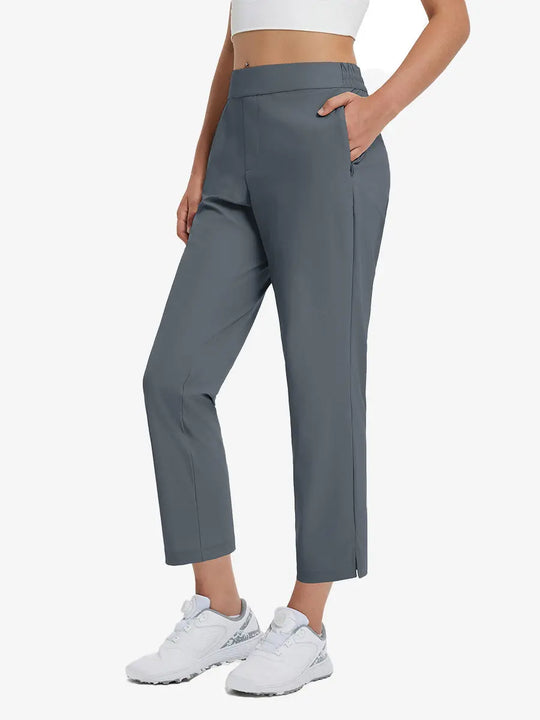 Front lower-body view of model with right hand in pocket wearing DARK GREY Women's 7/8 Ankle Golf Track Pants.