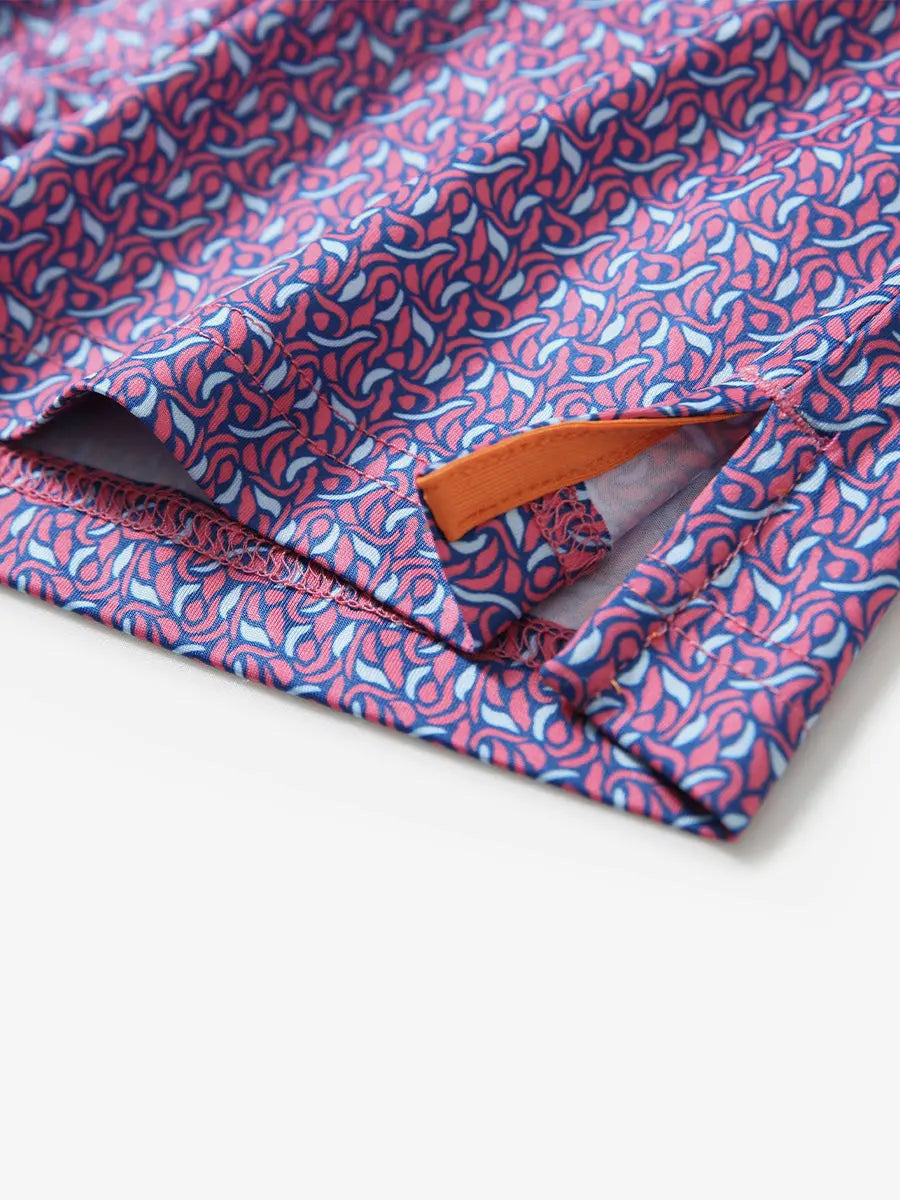 Detail view of the magenta geometric pattern polo shirt, showcasing the neat hem opening and bold design.