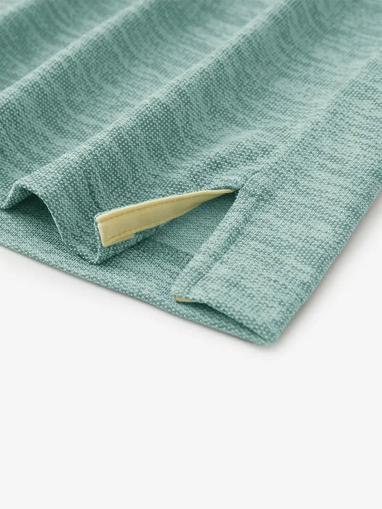 Hem slit detail of GREEN HEATHER Premium Stretch Heather Polo highlighting stitching and finish.